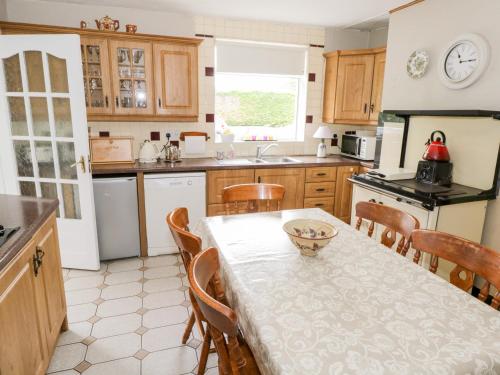 a kitchen with a table and chairs and a kitchen with a table and a table at Churchfield House in Ballina