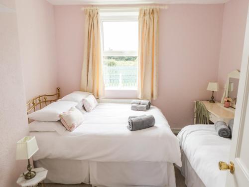 Duas camas num quarto com uma janela em Churchfield House em Ballina