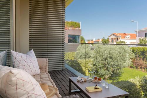 uma varanda com um sofá e uma mesa com vista em Garden View - Savoy Residence Casa Branca II no Funchal