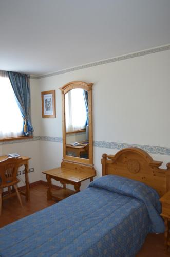 a bedroom with a bed and a mirror and a table at Park Hotel in Folgarida