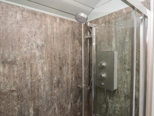 um chuveiro numa casa de banho com uma parede de betão em Two Moors Shepherds Hut em Exeter