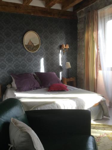 La Chaze-de-PeyreにあるLa ferme de Félixのベッドルーム(大型ベッド1台、椅子付)