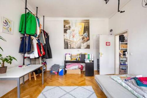 a living room with a table and a refrigerator at FRO-MEDIA - Streetside Room 2 - Community Space in Vienna