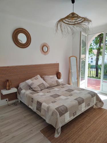 une chambre avec un lit et un miroir au mur dans l'établissement Villa avec piscine, à Capbreton