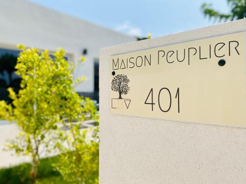 a sign in front of a mansion with a tree at Bella Vista Hôtel, Suites & Maisons in Porticcio