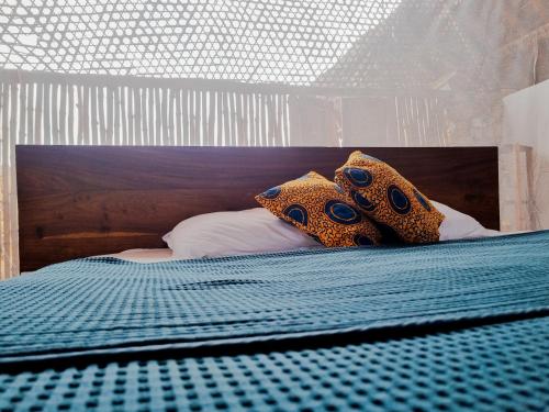 a bed with a wooden headboard and pillows on it at Pangani Cliffs Lodge in Pangani