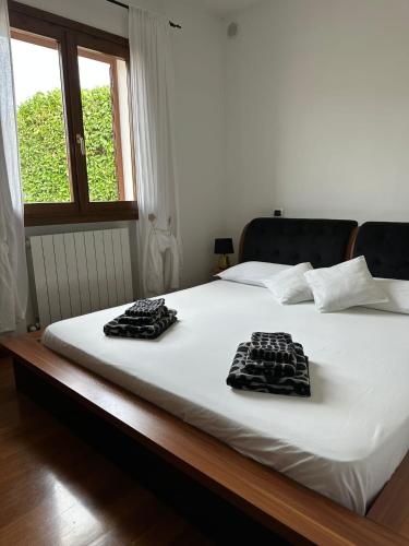 a white bed with two black towels on it at Pink House in Camporosso