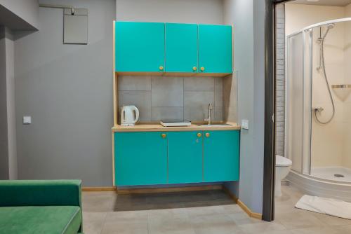 a bathroom with blue cabinets and a toilet at Apart Ivana Fedorova 30 in Lviv