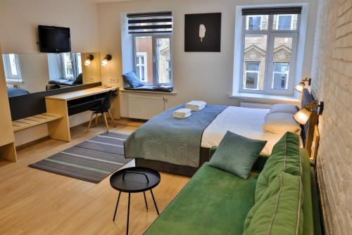 ein Schlafzimmer mit einem Bett, einem Sofa und einem Schreibtisch in der Unterkunft Apart Ivana Fedorova 30 in Lwiw