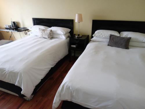 two beds sitting next to each other in a bedroom at Protea Hotel by Marriott Bloemfontein in Bloemfontein