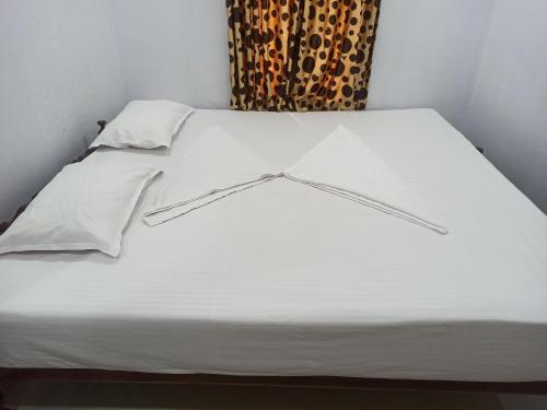 Pallipuram的住宿－EDEN BEACH VILLA，一张带白色床单和枕头的床,配有窗户
