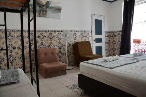 a bedroom with two beds and a chair and a window at RIA Terrace in Faro