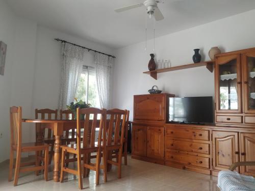 a living room with a dining room table and a tv at Mar1 in Carboneras