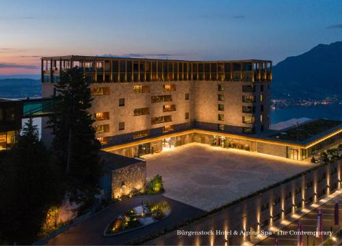 un gran edificio con un patio delante de él en Bürgenstock Hotel & Alpine Spa en Bürgenstock