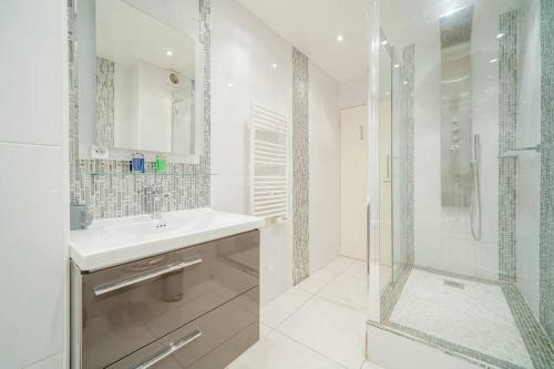 une salle de bain blanche avec un lavabo et une douche dans l'établissement Appartement familiale #Wagram #Pereire - II, à Paris
