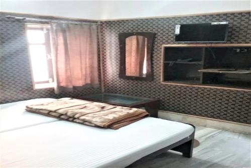 a bedroom with a bed with a blanket on it at Goroomgo Teerth Guest House Varanasi Near Temple and Ganga Ghat in Varanasi