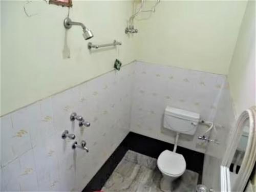 La salle de bains est pourvue de toilettes blanches. dans l'établissement Goroomgo Teerth Guest House Varanasi Near Temple and Ganga Ghat, à Varanasi