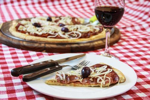 a table with a plate of pizza and a glass of wine at Hotel Itamarati Centro-República in Sao Paulo