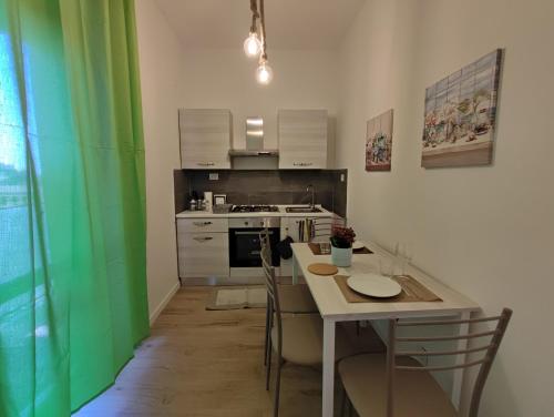 a kitchen with a table and a green wall at La casa sui tetti in Catania