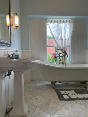 a white bathroom with a tub and a sink at The Jasmine Suite in Newark upon Trent