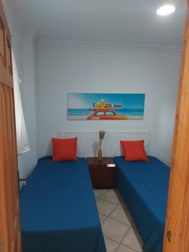 ベニカシムにあるApartamentos CHRISTINAの青と赤の枕が備わる客室内のベッド2台