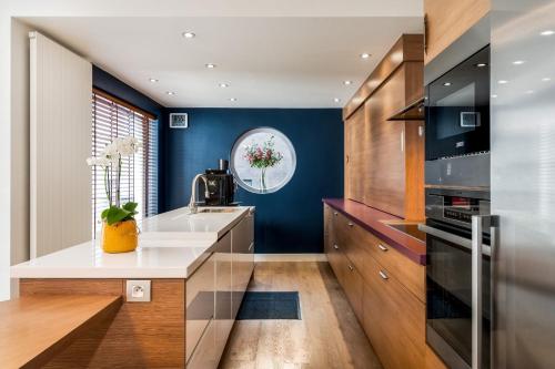 a kitchen with a white counter and blue walls at Huis @ Sint Kruis in Bruges