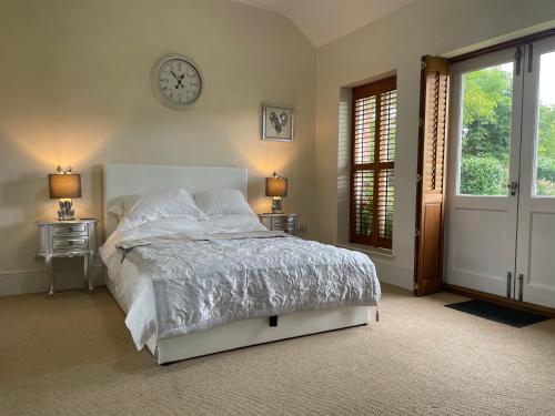 a bedroom with a bed and a clock on the wall at The Jasmine Suite in Newark upon Trent