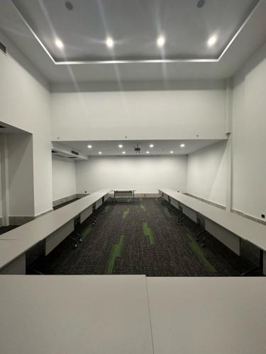 an empty room with rows of tables and benches at V Center Hotel in Trabzon