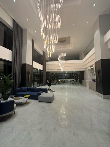 a lobby with blue couches and a chandelier at V Center Hotel in Trabzon