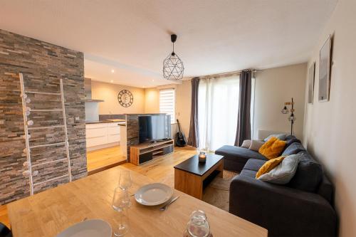 un salon avec un canapé et une table dans l'établissement Le Wood and Stone, à Toulouse