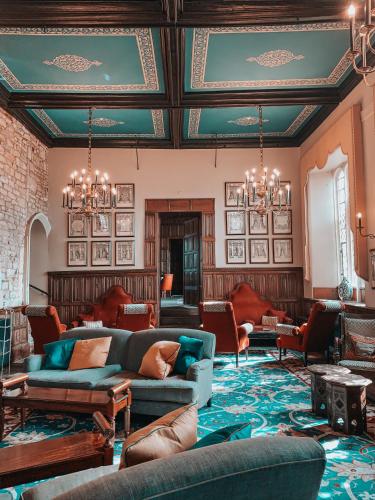 a living room with a blue couch and chairs at Ellenborough Park in Cheltenham