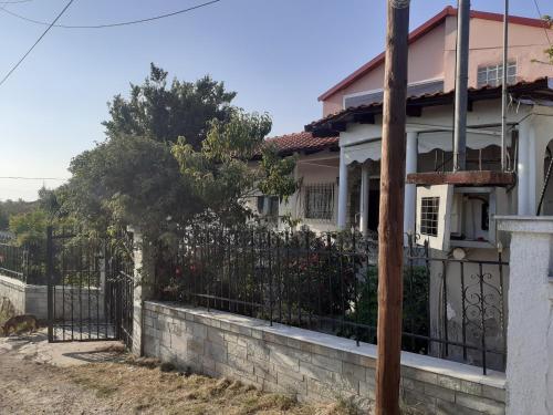 a house with a fence in front of it at kali SunnySide Up in Nea Kalikratia