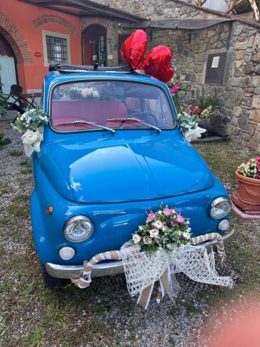 an old blue car with flowers on the front at Agriturismo Villa Le Vigne in Montevarchi