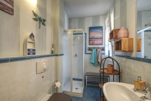 een badkamer met een douche, een wastafel en een toilet bij Apartment Dragonfly - garden and pool in Manerba del Garda