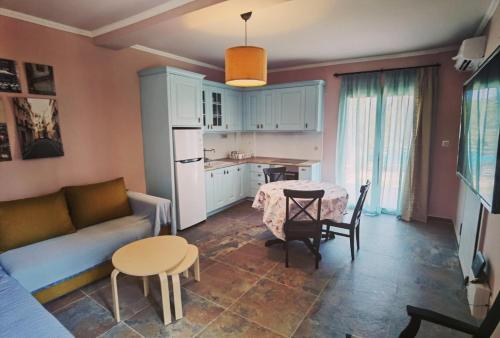 cocina y sala de estar con sofá y mesa en Elpida Suites en Nea Iraklia