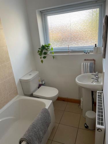 uma casa de banho com uma banheira, um WC e um lavatório. em Lovely 2 bedroom Apartment with Free Parking em Borrowash