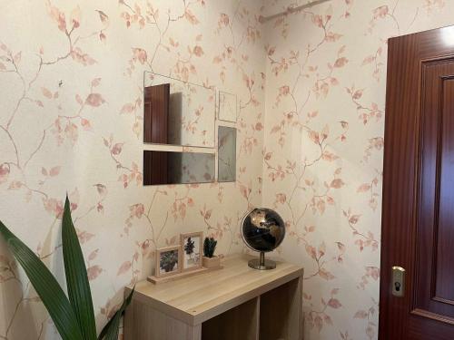 una camera con scrivania con specchio e fiori sul muro di Paxarinos Playa by FlowHome a Gijón