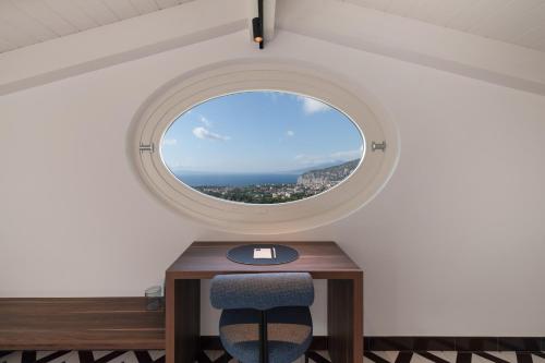 a round window in a room with a table and a chair at Gargiulo Resort in Sant'Agnello