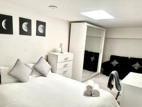 a white bedroom with a bed and a mirror at Lovely one bed Fitzrovia/soho in London