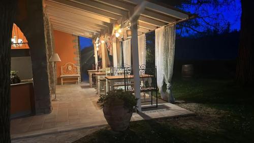 a patio with a table and chairs under a pergola at night at Agriturismo Villa Le Vigne in Montevarchi