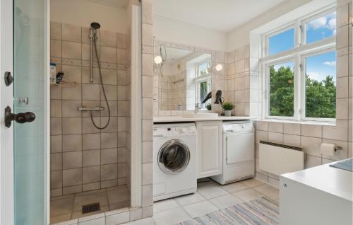bagno con lavatrice, asciugatrice e doccia di 2 Bedroom Pet Friendly Apartment In Svaneke a Svaneke