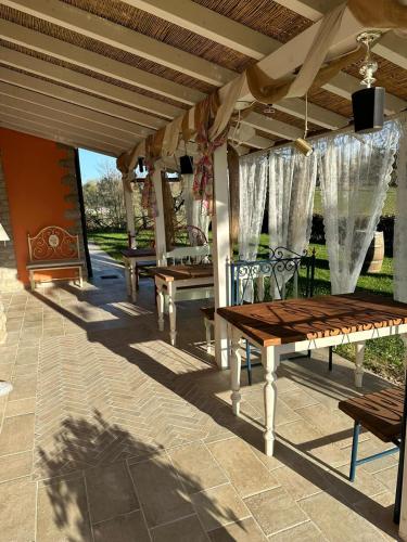 a row of wooden benches under a pergola at Agriturismo Villa Le Vigne in Montevarchi