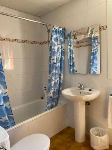 a bathroom with a sink and a toilet and a tub at Hostal Alt Llobregat in Castellar de NʼHug