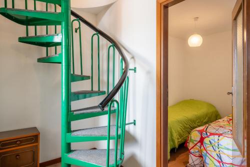PrataccioにあるCasa Maryのベッド付きの客室内の緑の螺旋階段