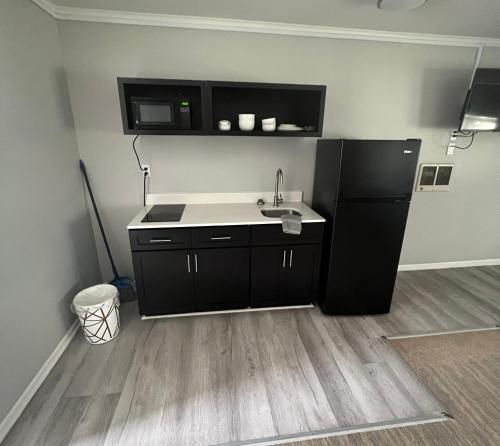 a kitchen with a sink and a black refrigerator at Salter Path Inn in Salter Path