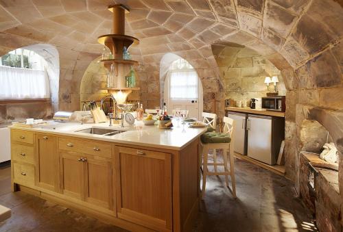 a kitchen with a sink and a stone wall at Temple of Diana in Shifnal