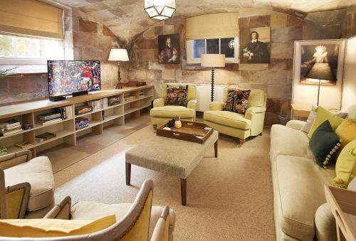 a living room with couches and a tv at Temple of Diana in Shifnal