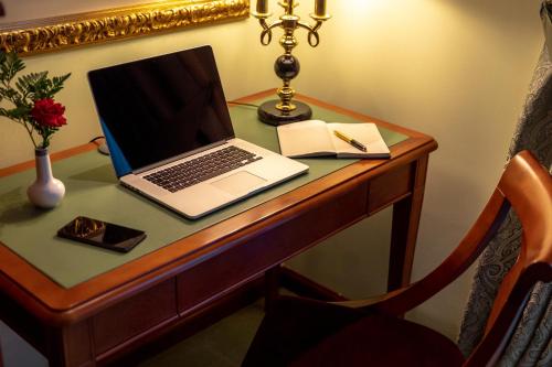 a desk with a laptop and a book on it at Swiss Diamond Hotel Prishtina in Pristina