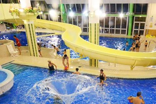 - un toboggan aquatique dans une piscine avec des personnes dans l'établissement Les Balcons du Soleil Appt303 à100m pistes 2 chambres parking couvert WIFI, à Orcières