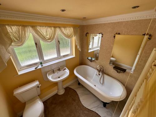a bathroom with a sink and a tub and a toilet at Reemdale Manor - Fulwood Row Preston PR25RW in Grimsargh